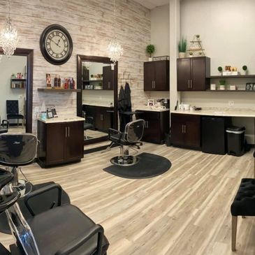 Modern hair salon with styling stations and a wash basin.