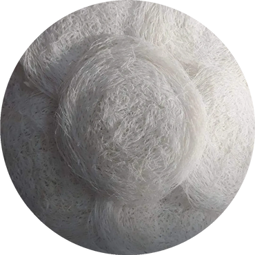 White textured hat with intricate lace and floral design.