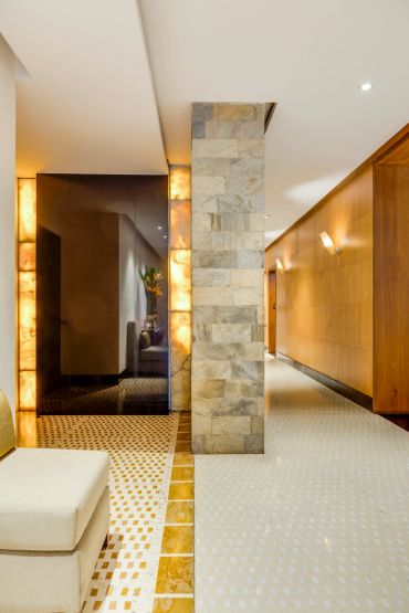 Modern hallway with stone pillar and warm lighting.