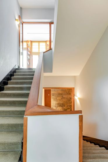 Modern staircase with wooden handrails and soft lighting.