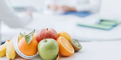 A variety of fresh fruits with a measuring tape symbolizing healthy eating.