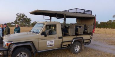 Safari vehicle parked in a field.