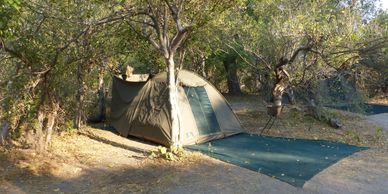 Tent set up in a wooded area for camping.