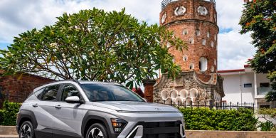 Silver SUV parked near a historic brick tower.