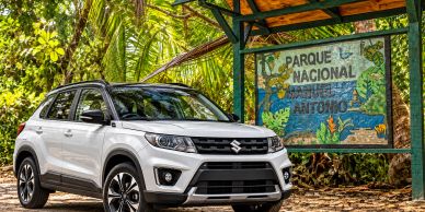 White Suzuki SUV parked near a national park sign.