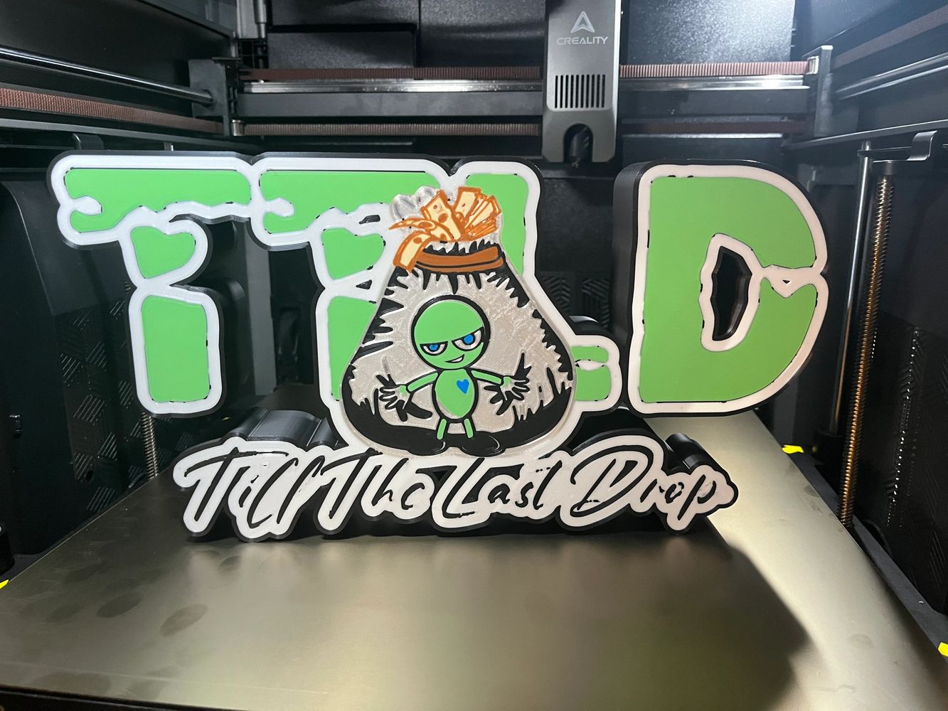 3D printed colorful sign with a character and text 'Turn The Last Drop'.