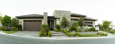 Modern single-story house with stone accents and well-maintained landscaping.