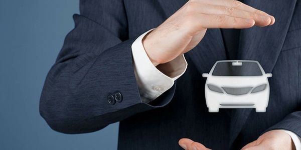 Businessman protecting a digital car icon between his hands.