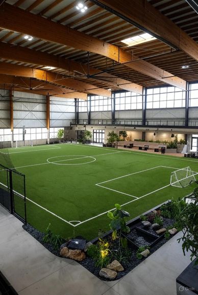 Indoor soccer field with artificial turf inside a spacious building.