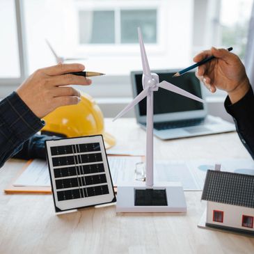 Two people discussing renewable energy models at a desk.