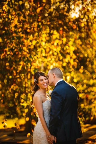 Bride and groom enjoying a tender moment outdoors.
