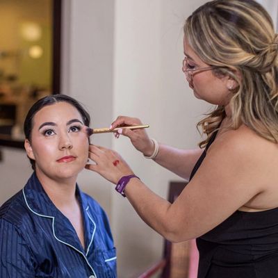 Woman applying makeup on another woman.