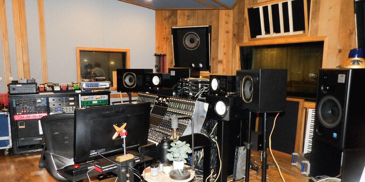 A professional recording studio with mixing consoles and speakers.