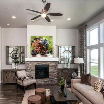 Modern living room with stone fireplace and colorful art.