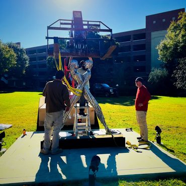 Art installation. lull operation, move sculpture to attach to concrete pad for long-term display.