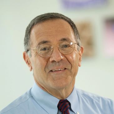Portrait of an elderly man wearing glasses.