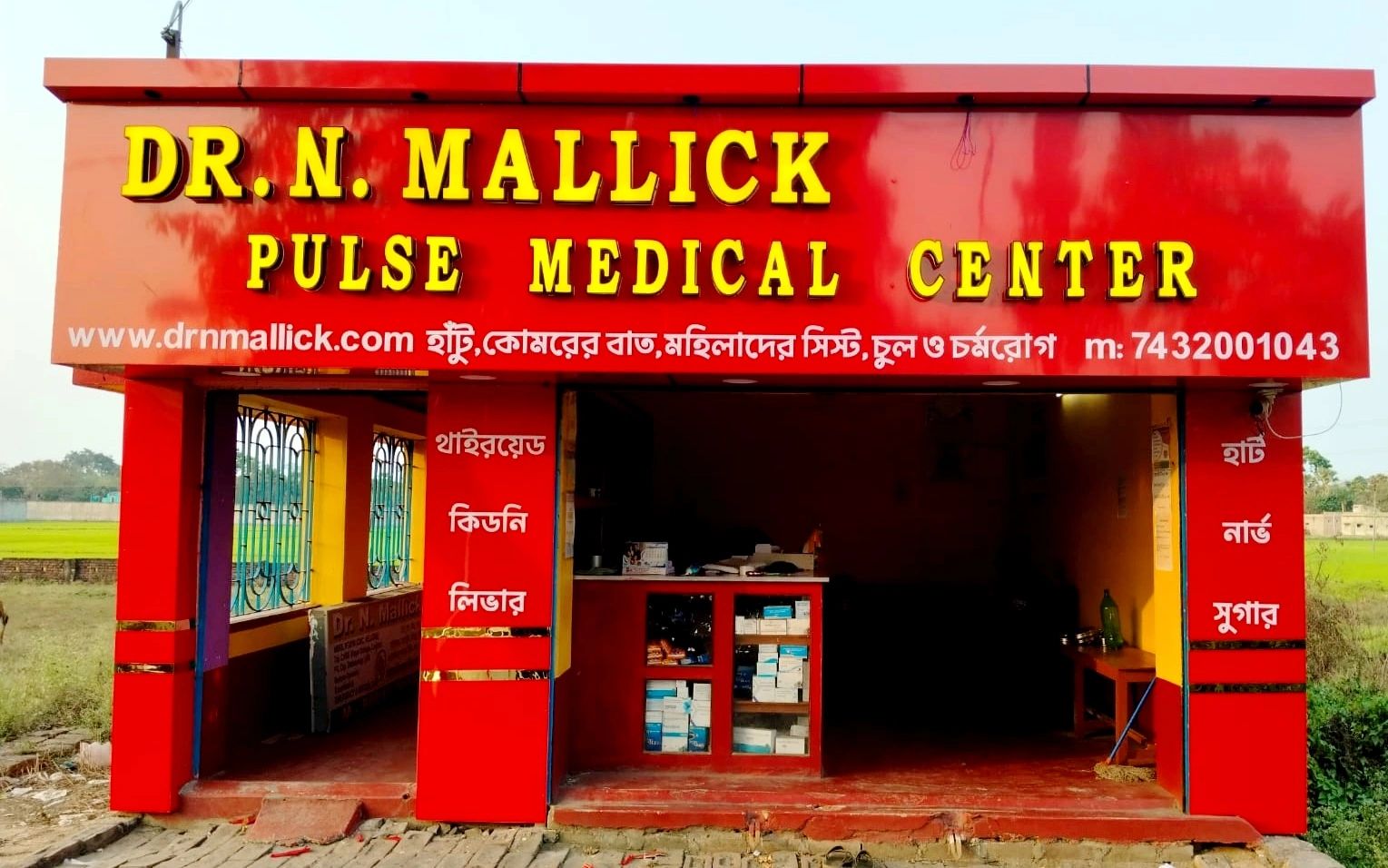 Red facade of Dr. N. Mallick Pulse Medical Center with medical supplies inside.
