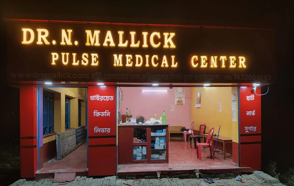 Dr. N. Mallick Pulse Medical Center illuminated at night with chairs and medical supplies inside.