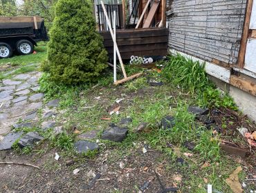 Messy garden area with tools and debris scattered.