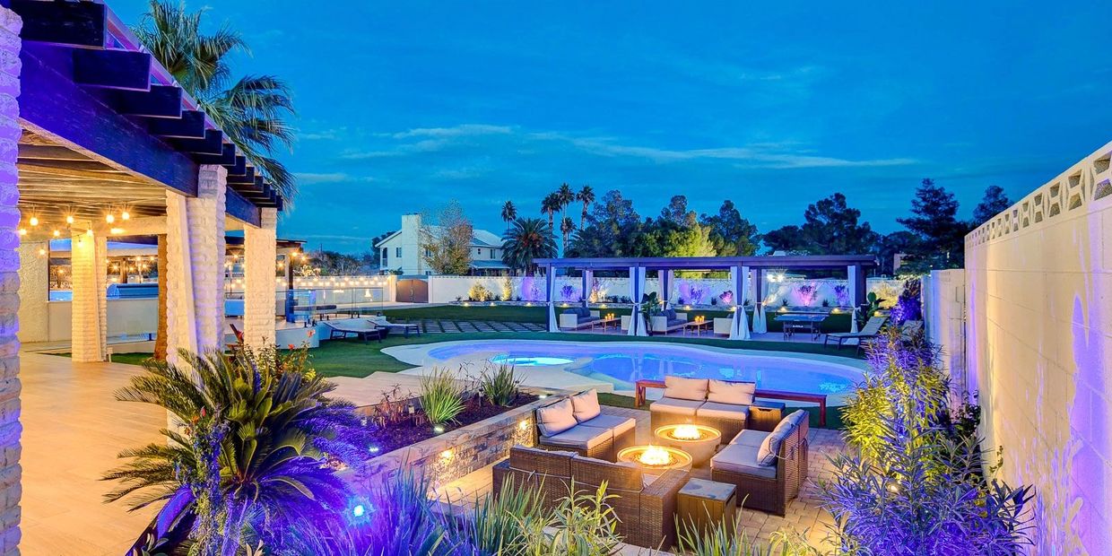 Purple lighting around patio setting next to pool.