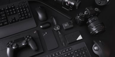 A collection of black tech gadgets and accessories neatly arranged on a dark surface.