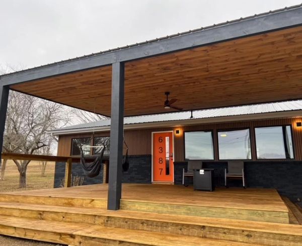 Front porch with 2 hanging chairs and fire pit