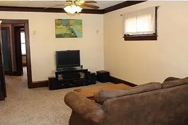 Cozy living room with brown couch, TV, and carpeted floor.