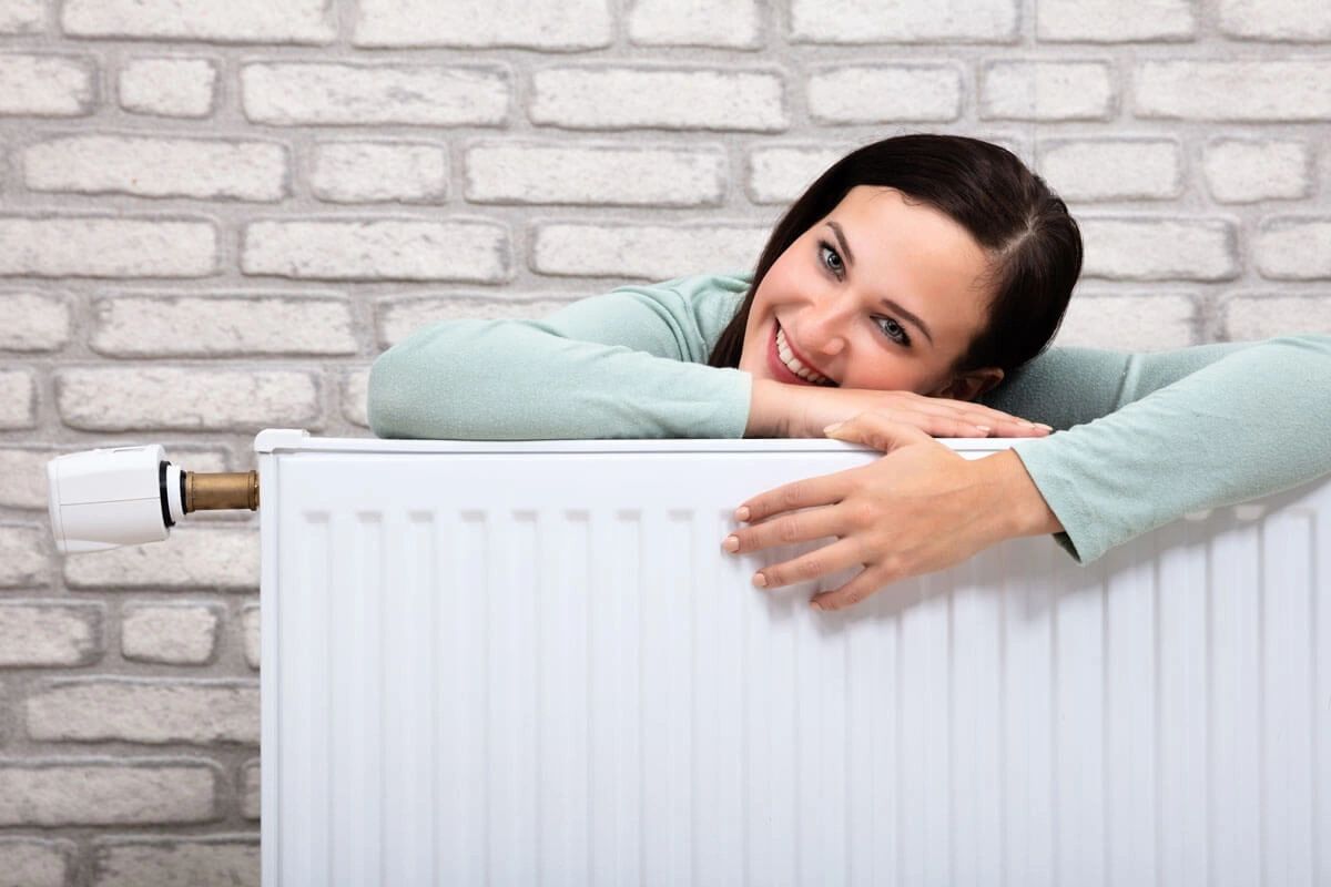 after getting the free boiler installed for benefits holders a women happily hugging the radiator.