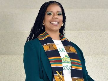 Young woman wearing a colorful graduation stole.
