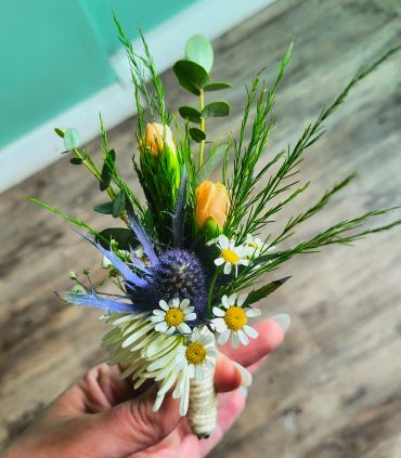 Boutonniere with wildflowers and greenery.