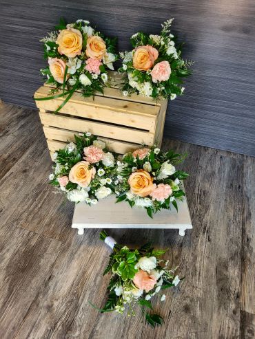 Elegant floral arrangements with peach roses and greenery.