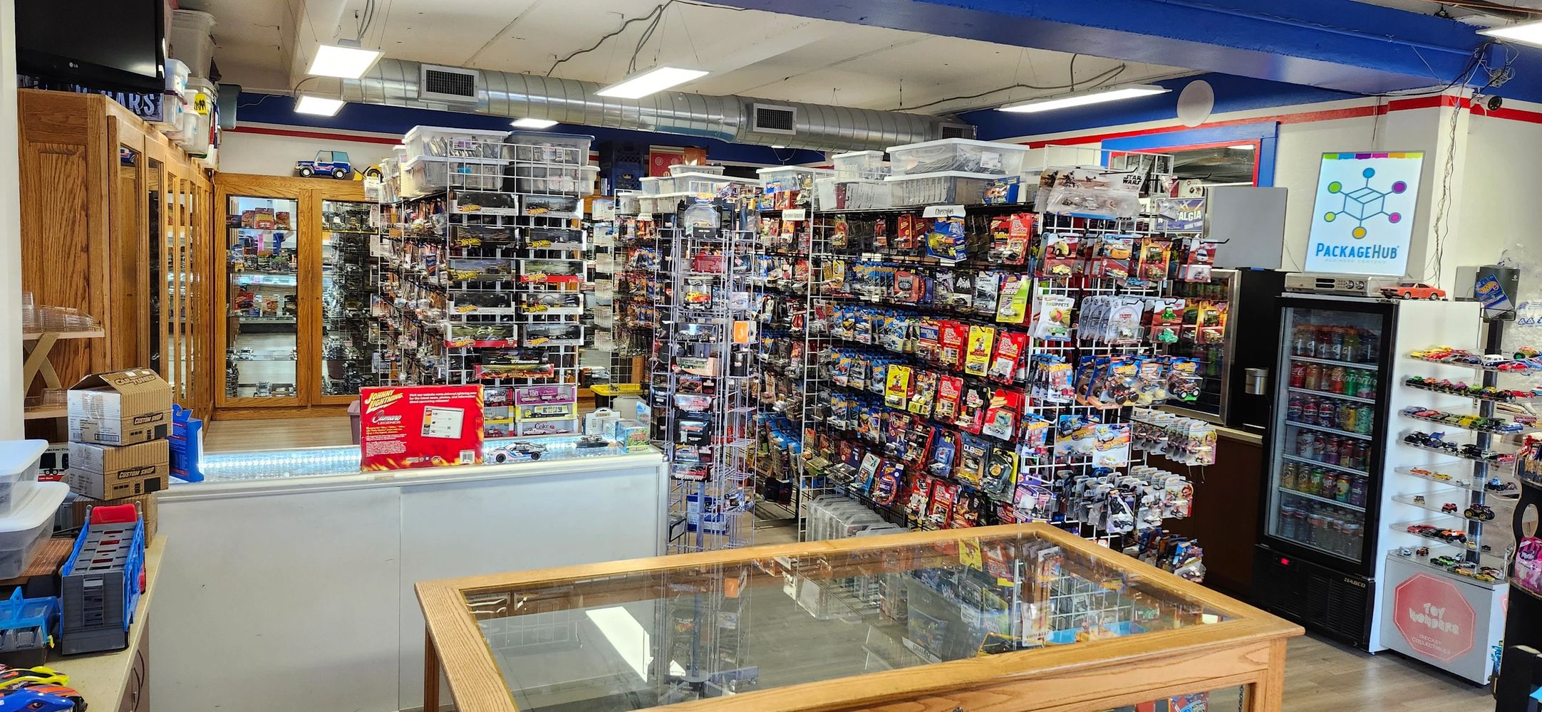 Toy store packed with collectible cars and merchandise on display racks.