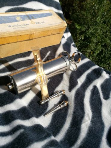Vintage Wundspitze 500 ml medical instrument with box on striped fabric.