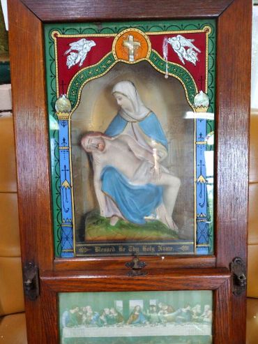 Religious artwork depicting the Pietà in a wooden frame.