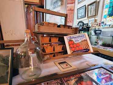 Old wooden display with jars and vintage signs.