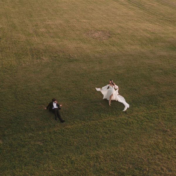 Couple in formal wear on a grassy field.