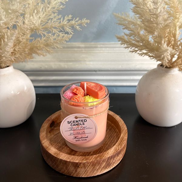 Handmade tropical island scented candle with decorative dried plants.