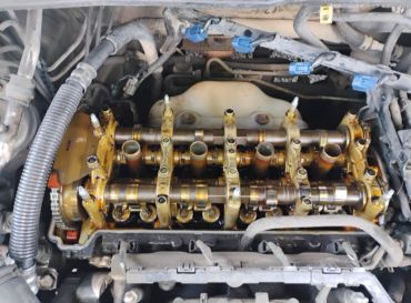 Open engine cylinder head with camshafts visible.