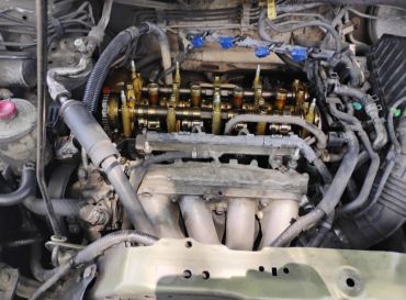 Car engine with exposed camshaft and intake manifold.