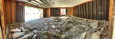 Garage interior with broken concrete floor and exposed wall framing.