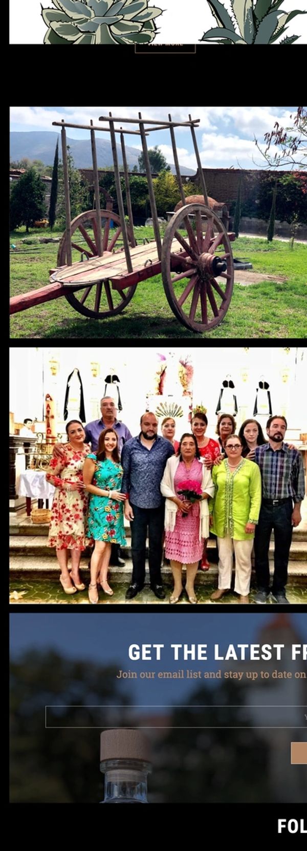 Group of people posing indoors with a rustic wooden cart outdoors.