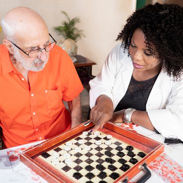 Elderly man and woman playing backgammon.