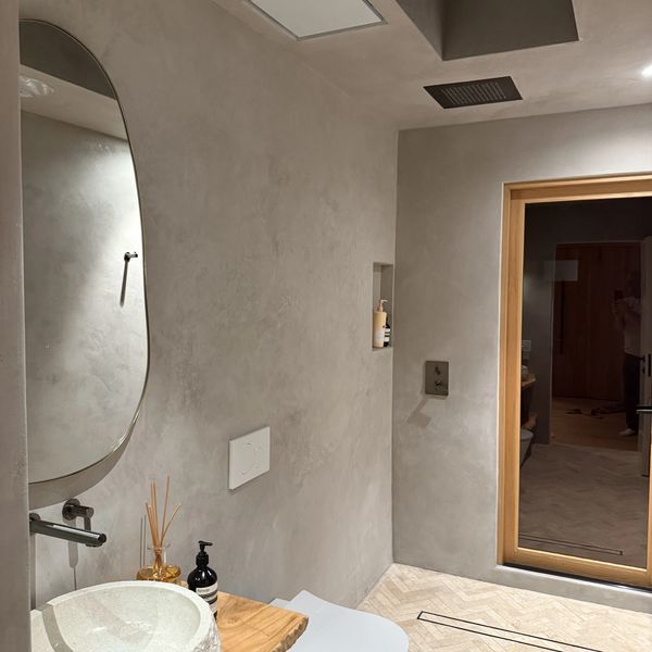 Modern minimalist bathroom with concrete walls and wooden accents.