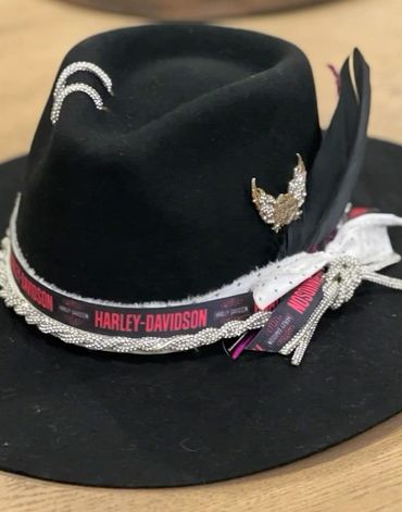 Black Harley-Davidson hat with decorative pins and ribbons.