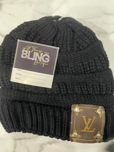 Black knit beanie with a Louis Vuitton patch and a boutique tag.