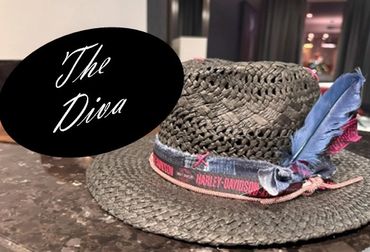 Woven hat with feathers and a pink Harley-Davidson band.