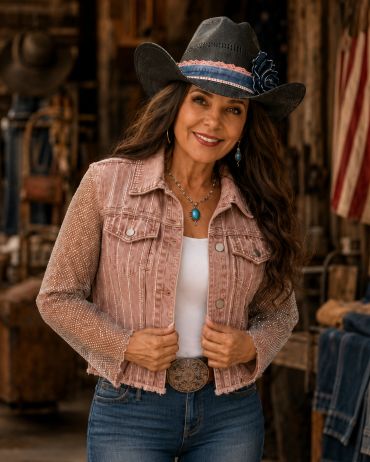 Woman in a stylish cowboy hat and pink jacket.