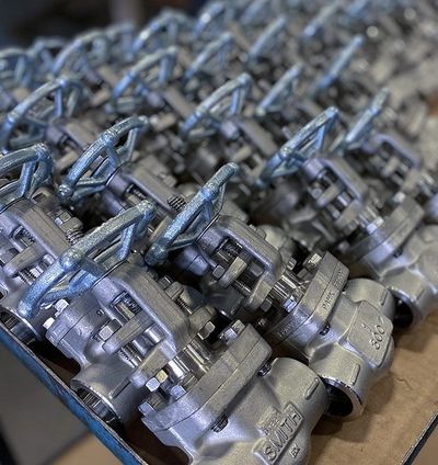 A row of metallic industrial valves with handwheels arranged neatly.