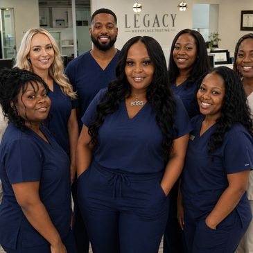 A group of smiling healthcare professionals in navy blue scrubs.