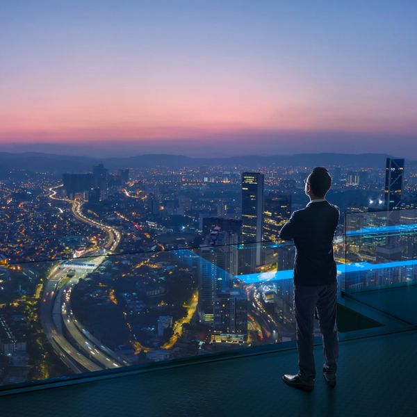 man on a balcony over looking the city